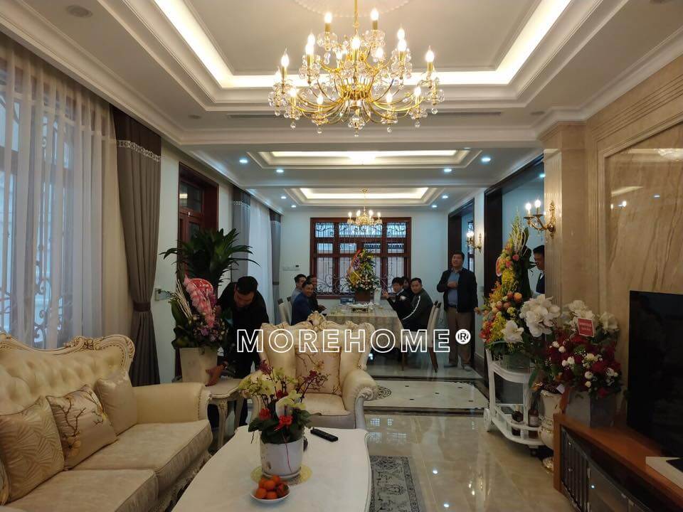 Không gian phòng khách tân cổ điển được bày trí bộ sofa da, đèn chùm, kệ trang trí cao cấp,... Lựa chọn các mẫu thiết kế phòng khách biệt thự, nhà phố đẹp